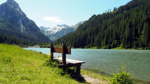 Empty Wodden Bench in front of lake Schliereralmsee with mountain scenery in Foto stock