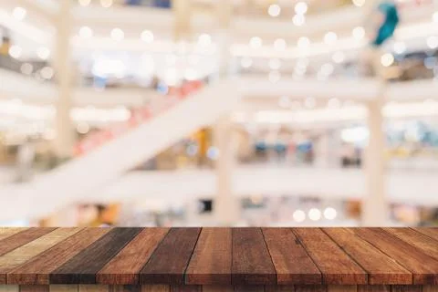Empty wood table and blurred light table in shopping mall with bokeh backgrou Stock Photos