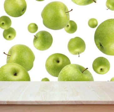 Empty wood table on background of flying green apples. Stock Photos