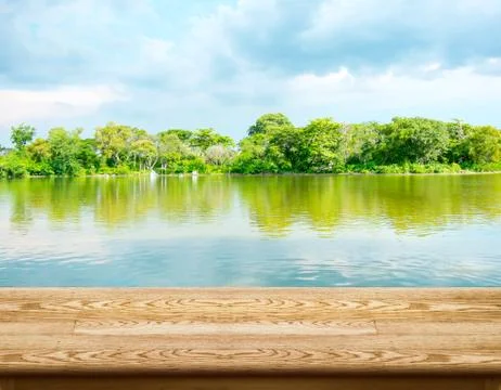Empty wood table with lagoon at forest and blue sky at background Stock Photos