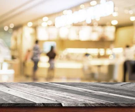 Empty wood table top with coffee shop blur with bokeh background Stock Photos
