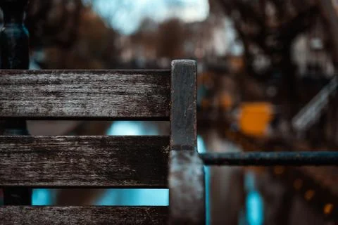 Empty Wooden Bench Closeup Corner Waterfront Bridge Depth of Field Urban Scene Stock-Fotos