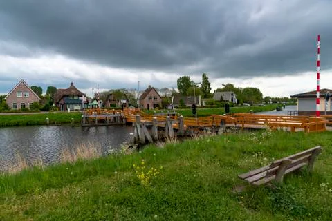 Empty wooden bench facing the mobile bridge over the canal under a straighten 库存照片