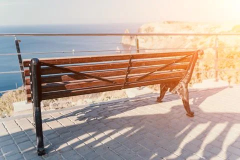 An empty wooden bench with a viewpoint looking out to sea. Wooden bench in city Stock Photos