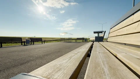 Empty Wooden Benches Sit at a Quiet Roadside Rest Stop Under a Bright Sun Stock Footage 335112796