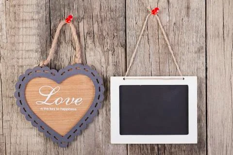 Empty wooden blackboard sign and heart shape frame Фото