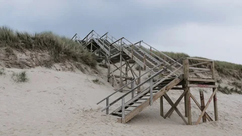 Empty wooden boardwalk with steps on sandy beach Stock Footage 71565822