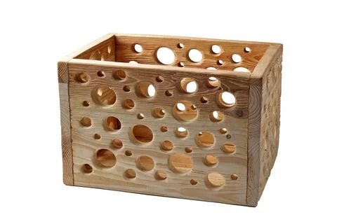 Empty wooden box with patterned holes isolated on white background at an angl Stock Photos