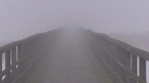 Empty wooden bridge on winter lake and morning fog Stock Footage