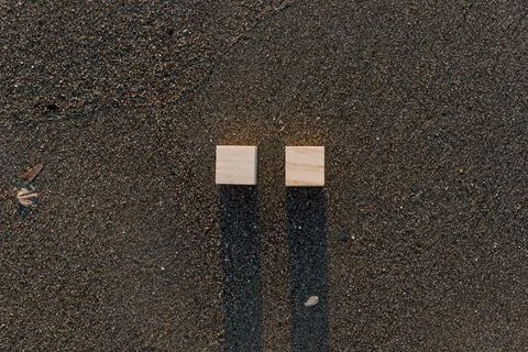 Empty wooden cubes with copy space for text on sandy summer beach background Stock Photos