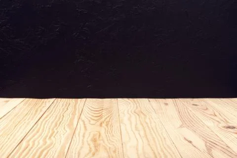 Empty wooden deck table and black textured wall background Stock Photos
