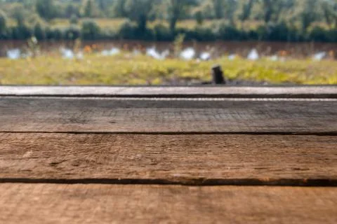 Empty wooden deck table with foliage bokeh background. Ready for product display Stock Photos