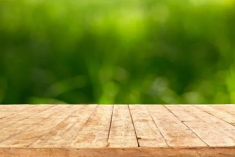Empty wooden deck table with foliage bokeh background. Ready for product disp Foto stock