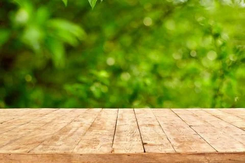 Empty wooden deck table with foliage bokeh background. Foto stock