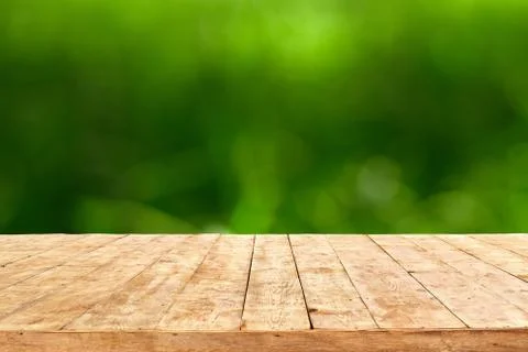Empty wooden deck table with foliage bokeh background. Ready for product disp Foto stock