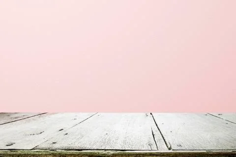 Empty wooden deck table over rusty pink background for present product. Stock Photos