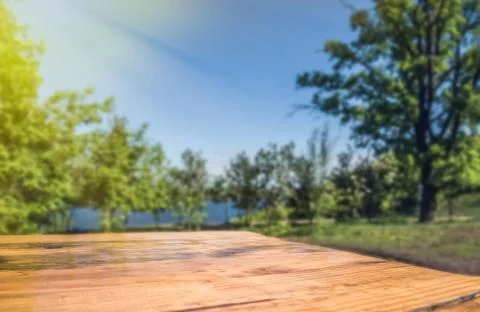 Empty wooden deck table with park blur background. Stock Photos