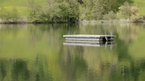 Empty wooden floating platform with metal container as floating body on lake Stock Footage 155311313