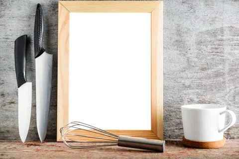 An empty wooden frame and kitchen accessories on a wooden background Stock Photos