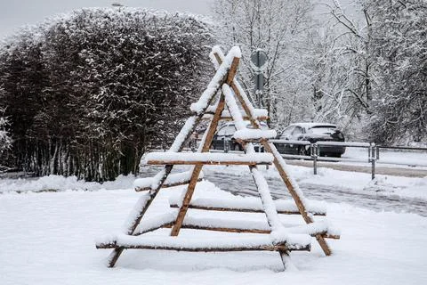 Empty wooden frame for haystack covered with snow in winter. Urban design object Stock Photos