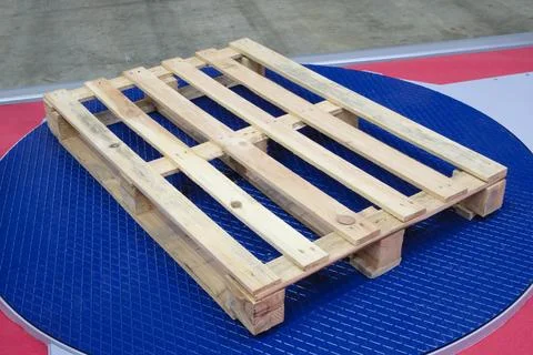 An empty wooden pallet, ready for loading, sits in a warehouse or factory. Pa Stock Photos
