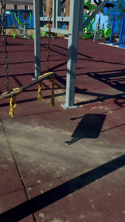 Empty wooden swing on playground with red rubber surface Stock Footage 341715857