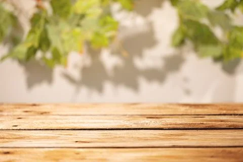 Empty wooden table with blurred grape leaves and soft shadows as rustic aut.. Foto stock
