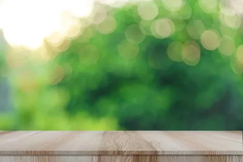 Empty wooden table with blurred green nature background Stock Photos