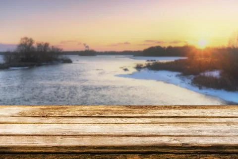 Empty wooden table with blurred picteresque winter background of riverside at Stock Photos