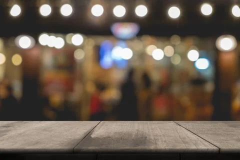 Empty wooden table of brown in front Warm orange color of bokeh on wooden bac Stock Photos