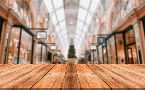 Empty wooden table in front of abstract blurred background of shopping mall Stock Photos