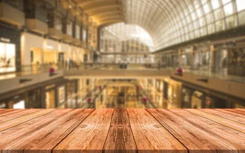 Empty wooden table in front of abstract blurred background of shopping mall Stock Photos