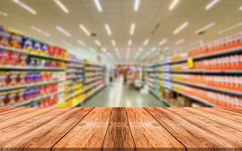 Empty wooden table in front of abstract blurred background of shopping mall Stock Photos
