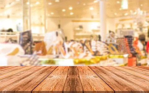 Empty wooden table in front of abstract blurred background of shopping mall Stock Photos