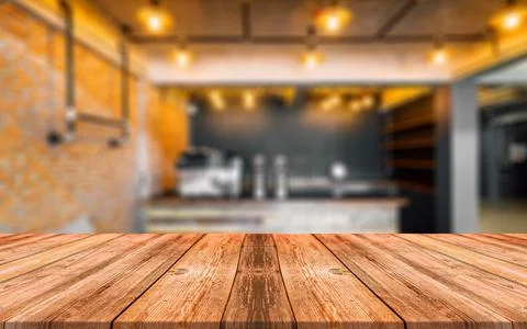 Empty wooden table in front of abstract blurred background of coffee shop Stock Photos