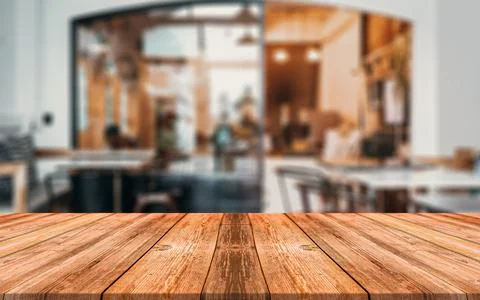 Empty wooden table in front of abstract blurred background of coffee shop Stock Photos