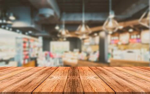 Empty wooden table in front of abstract blurred background of coffee shop Stock Photos