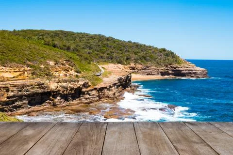 Empty wooden table in front of Australian rock formation with ocean in backgr Stock Photos
