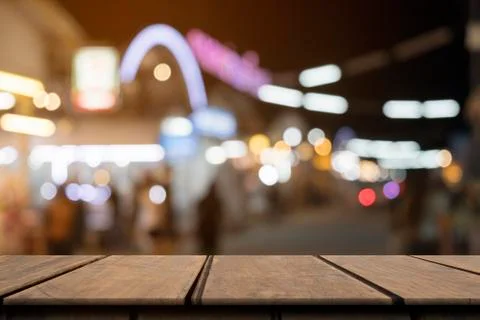 Empty wooden table on front blurred colorful night street background, copy sp Stock Photos