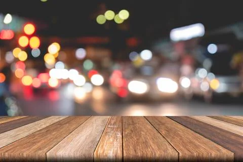 Empty wooden table on front blurred traffic bokeh background, for presentatio Stock Photos
