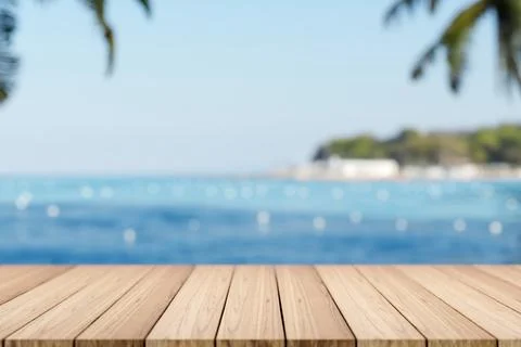 Empty wooden table or plank bench or boardwalk bridge across blue sea and i.. Illustrazione stock