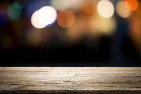 Empty wooden table platform and bokeh at night. Stock Photos