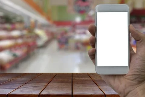 Empty wooden table space platform and Hand holding smartphone with white blan Stock Photos