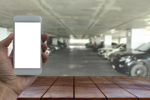 Empty wooden table space platform and Hand holding smartphone with white blan 스톡 사진