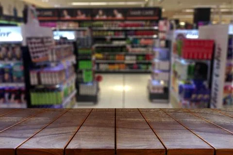 Empty wooden table space platform and blurred Supermarket aisle with product  Stock Photos