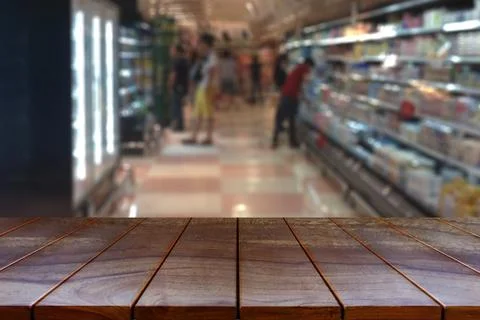 Empty wooden table space platform and blurred Supermarket aisle with product  Stock Photos