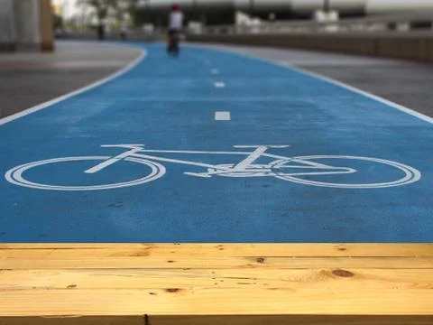 Empty wooden table space platform and blurred the only way for cyclists backg Stock Photos