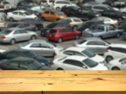 Empty wooden table space platform and blurred outdoor parking lot full of car Stock Photos