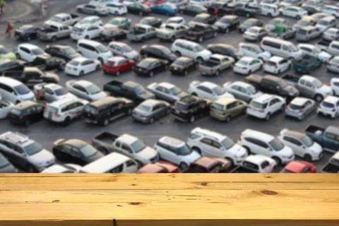 Empty wooden table space platform and blurred outdoor parking lot full of car Stock Photos