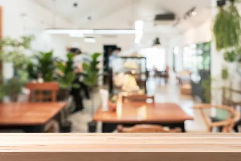 Empty wooden table space platform and blurry defocused restaurant interior 写真素材
